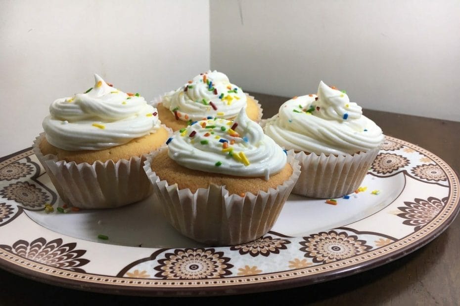 Yadda ake vanilla cupcakes Abubuwan hadawa 1. Flour kofi 2 2. Baking powder tsp 2 3. Gishiri tsp ½ 4. Butter kofi 1 (mai laushi sosai wato softened) 5. Sugar kofi 1 (confectioners) 6. Coconut milk kofi 1 7. Kwai 4 8. Vanilla na gari tsp 2/3 Yadda ake hadawa 1. A cikin bowl ki zuba kayan hadinki busassu; flour da baking powder da kuma gishiri da garin vanillarki. Sai ki juya su su hadu da kyau. 2. Ki saka butter da sugar a bowl ki yi ta juyawa da electric mixer sai sun hadu. Amma idan ba ki da electric mixer za ki iya amfani da whisk (ko wani abin da zai yi mixing da shi) na ki har sai komai ya hudu sun yi laushi. 3. Ki kawo kwanki ki zuba daya idan kin juya kadan sai ki zuba dayan ma ki juya. Haka har ki kare kwanki guda hudu. 4. Idan sun dan hadu sai ki kawo coconut milk na ki, ki zuba kadan ki juya sai ki zuba hadin filawarki kadan ki juya. Haka za ki ta yi har sai filawarki da coconut milk sun kare tas. Ki tabbatar kin hada komai sun hadu sosai. 5. Idan kin gama, ki rika diban kullinki kin a zubawa a cikin cupcake cups na ki. Ki saka daidai, kar ki cika, ki sa ya kai kamar rabi da kwata na kofin din. Sai ki saka a preheated oven na ki (350). 6. Sai ki sauke bayan minti 20 ko kuma idan kin duba da tsinke ya fita sumul. Whip cream Abubuwan hada whip cream 1. Whip cream powder (sachet 2) 2. Madara na ruwa (full fat) kofi 1 3. Vanilla na gari tsp ½ 4. Colored sprinkles (cikin hannu) Yadda ake hadawa 1. Ki samu bowl tsukakke mai zurfi, da whisk, da madara, da kuma garin whip cream na ki ki saka su cikin fridge su yi sanyi sosai. 2. Bayan sun yi sanyi sosai sai ki hada su duka da vanillarki cikin wannan bowl mai sanyi ki ta whisking na su har na tsawon minti 4 ko sai kinga yadda ki ke so. 3. Ki yi amfani da pipping bag ki yi decorating na cupcakes na ki yadda ki ke so. 4. A karshe ki watsa sprinkles na ki a kai daidai yadda ki ke so.
